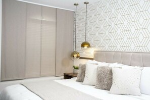 Ein Schlafzimmer mit einem Bett, Nachttischen, einem Kleiderschrank und einer Wand mit Muster.