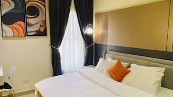 Una habitación de hotel con una cama, un escritorio y una silla.
