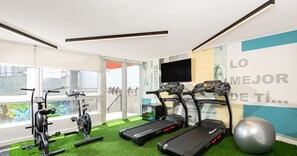 A gym with treadmills, stationary bikes, and a large exercise ball. - Casa Bustamante by Domus Travels (Ñuñoa)