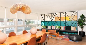 A modern interior with a dining area, seating, and a view through large windows. - Casa Bustamante by Domus Travels (Ñuñoa)