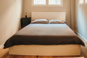 A single bed with a headboard, a bedside table with a bottle, and a window above the bed. - Urban Suite - Lakeside L&b (Milano)