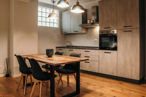 A modern kitchen with wooden cabinets, a built-in oven, and pendant lighting. - Urban Suite - Lakeside L&b (Milano)