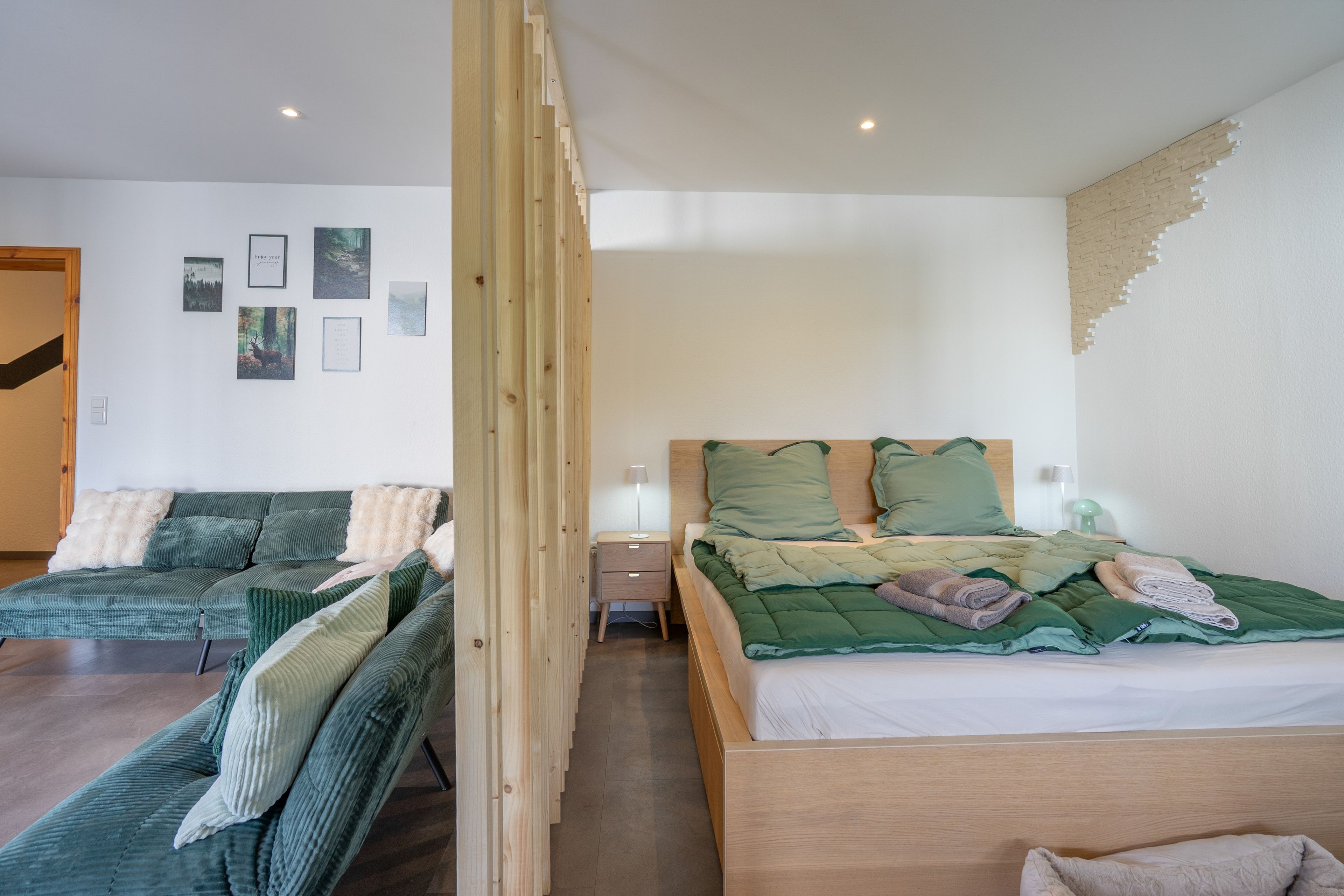 Een slaapkamer met een bed, een slaapbank en een nachtkastje.