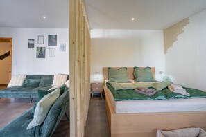 A bedroom with a bed, a sofa, and a nightstand.