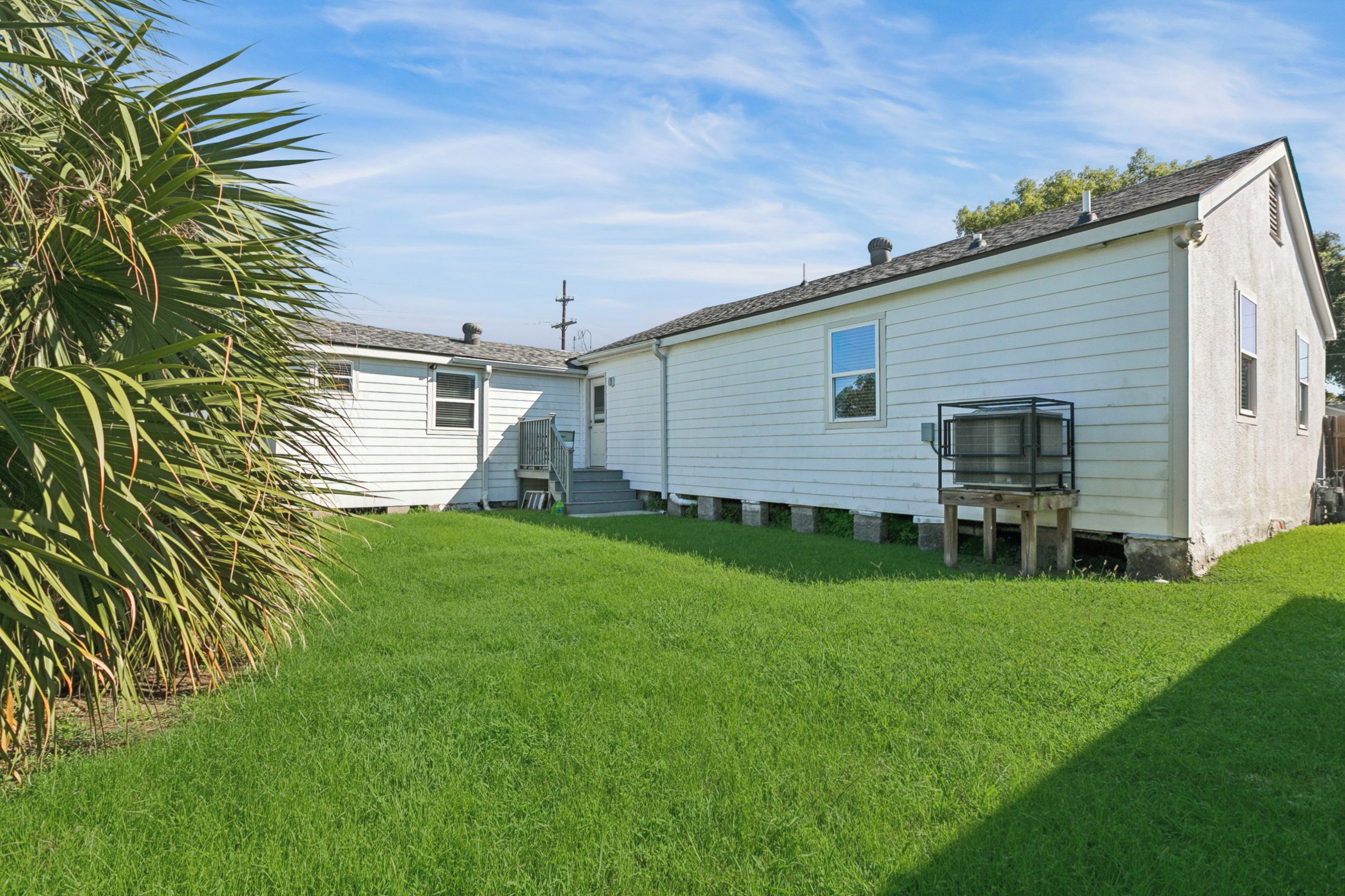 A single-story mobile home with a small porch and a fenced yard.