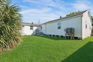 A single-story mobile home with a small porch and a fenced yard.