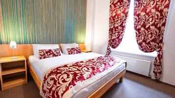 A bedroom with a bed, a nightstand, a window with curtains, and a wall with vertical lines.