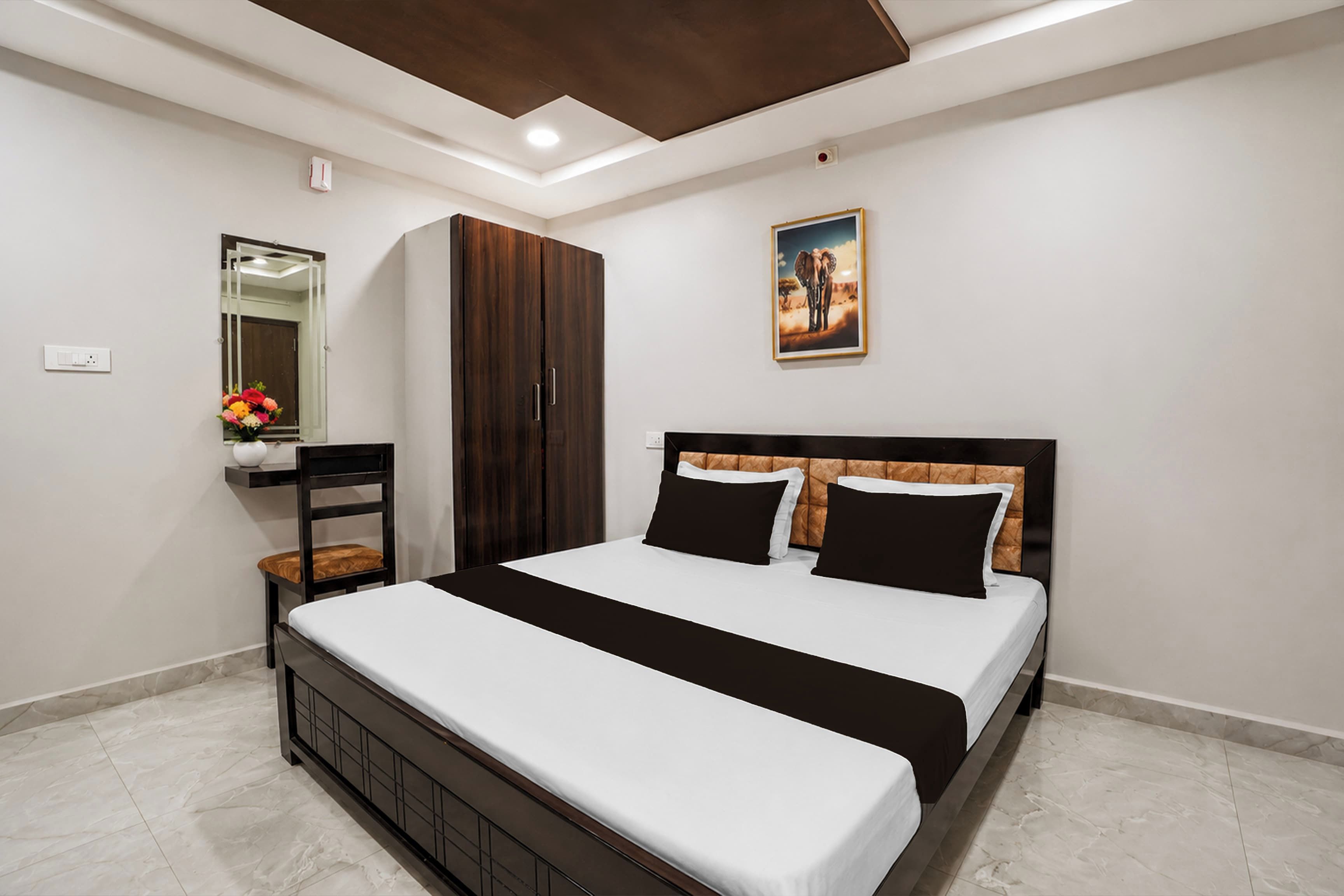 Une chambre à coucher moderne avec un lit, une armoire, une chaise, un miroir et un tableau accroché au mur.