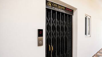 Ein schwarzes Metallgitter mit digitalem Schloss und einem Schild darüber mit der Aufschrift 'CSN GRAND 3. Etage Rezeption'.