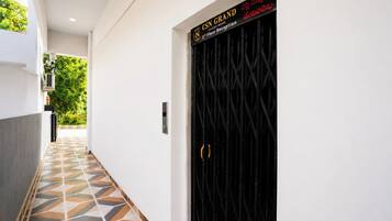 Un couloir au sol décoré de motifs menant à une porte portant l’inscription « Réception CSN, 3e étage ».