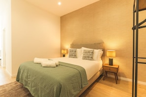 Ein Hotelzimmer mit Bett, Kissen, Nachttisch und Lampe.