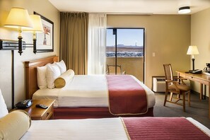 Ein Hotelzimmer mit Bett, Nachttisch, Stuhl, Schreibtisch und Blick auf die Landschaft.