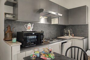 Una cuina moderna amb microones integrat, forns i una campana extractora d'acer inoxidable.