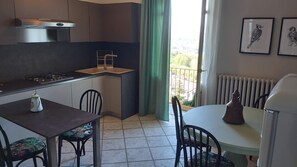A compact kitchen with a gas stove, a sink, and a dining area with chairs and a table.