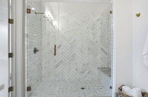 A glass-enclosed shower with a herringbone tile pattern and a metal handle. - THE MAGNOLIA - SLEEPS 12 / 2 KINGS / WALK TO DOWNTOWN ROANOKE (Roanoke)