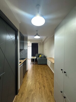 A modern interior with a kitchen, dining area, and a sofa.