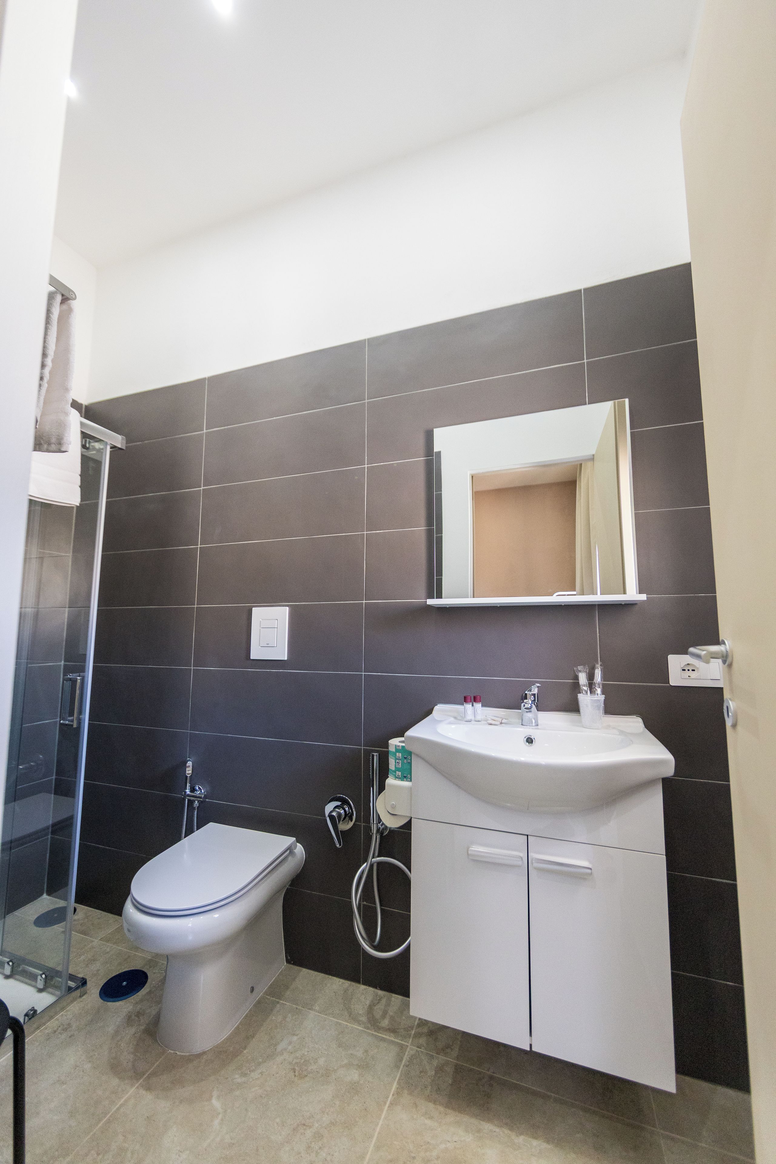 A bathroom with a toilet, sink, and shower.