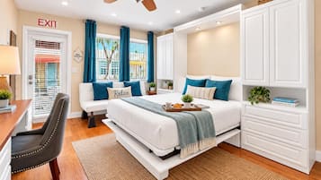 A bedroom with a bed, a desk, a chair, a wardrobe, and a ceiling fan.