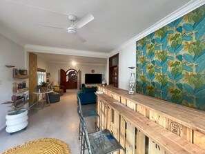Ein modernes Wohnzimmer mit einer Holztrennwand, einem großen Fernseher und einer Wand mit Muster.