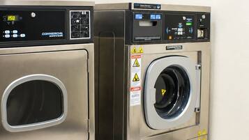 Two commercial-grade front-loading washing machines in a corner.
