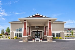 A two-story building with a stone facade, large windows, and a covered entrance area. - ADA Queen Room w/ Kitchen & Free Breakfast (Moses Lake)