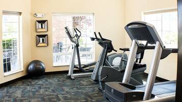 A fitness room with treadmills, an elliptical, and a stationary bike.