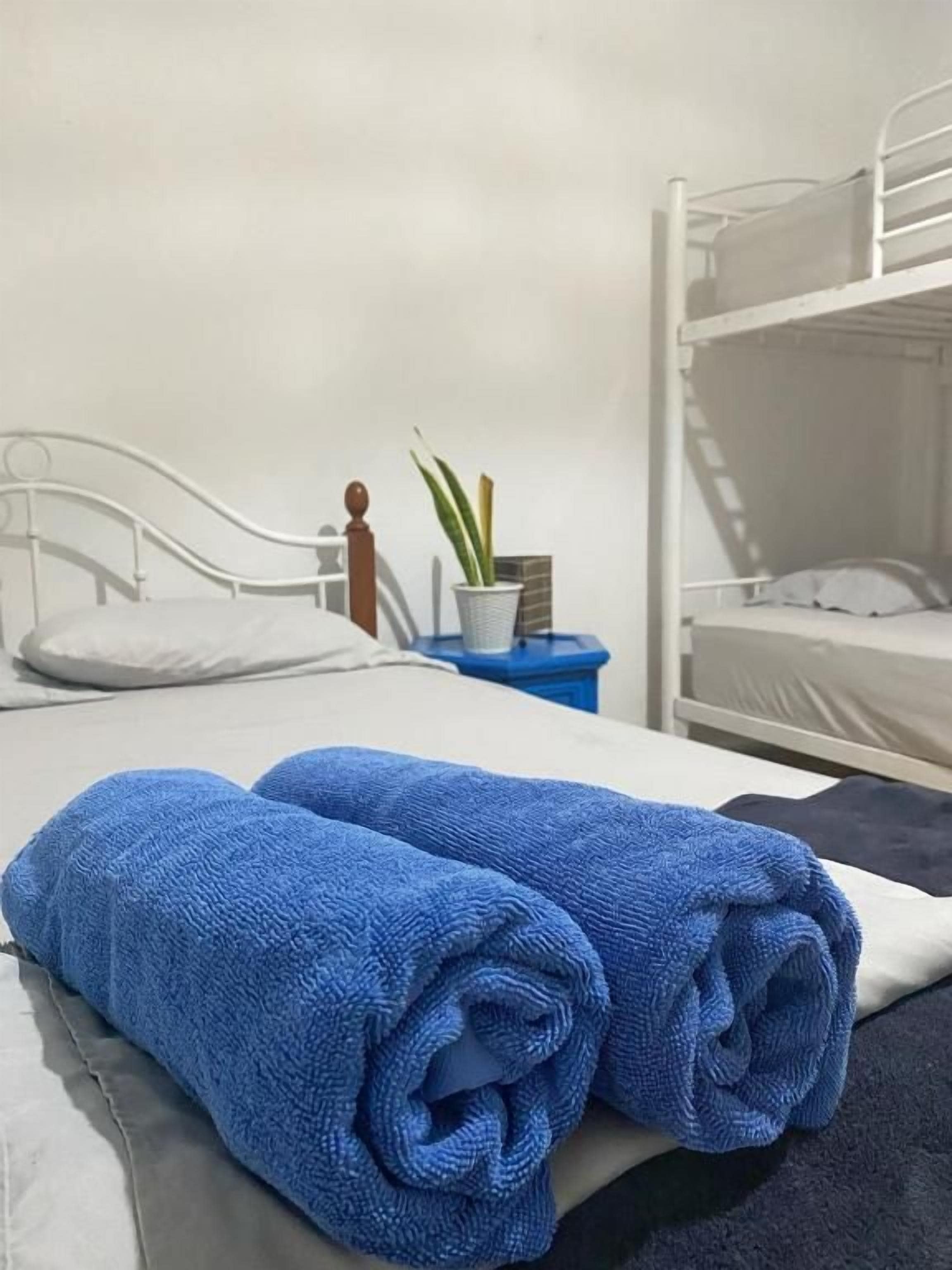 A single bed with a white headboard and a blue towel on it.