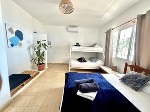 A room with bunk beds, a potted plant, and a window with curtains. - CASA GRECA (Río Hato)