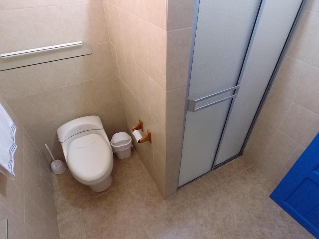 Pieni kylpyhuone, jossa on wc, bidee ja roskakori.