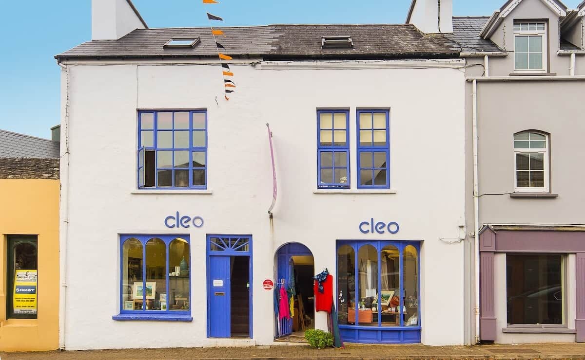 Edifício de dois andares com a identificação 'cleo' no andar térreo, com grandes janelas e fachada visível.