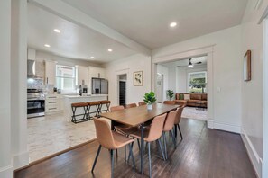 A modern kitchen with white cabinetry, a stainless steel refrigerator, and an oven. - Stay Roanoke | Patterson Pad | Roomy 3BR in Town (Roanoke)