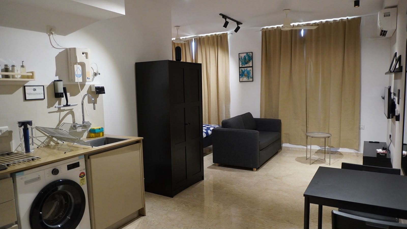A compact living space with a kitchenette, a sofa, and a dining area.