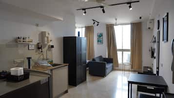 A compact living space with a kitchenette, a sofa, and a dining table.