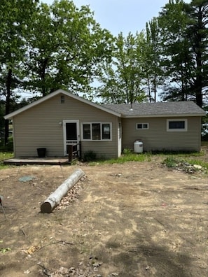 A single-story house with a front door, windows, and a small porch. - Cozy 3-bedroom lake house in charming Canterbury (Canterbury)