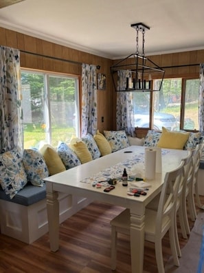 A dining area with a long table, multiple chairs, and a bench with cushions. - Cozy 3-bedroom lake house in charming Canterbury (Canterbury)