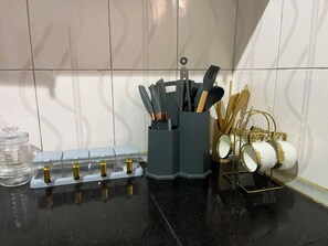 Eine Küchenarbeitsplatte mit einem Messerblock, einer Tasse und einem Glasbehälter.