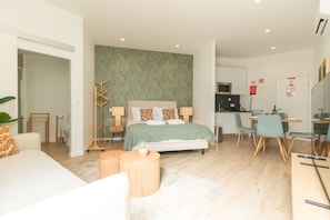 A modern bedroom with a bed, bedside tables, a small round table, and a green wall. - Rosa Studio by Atlantic Holiday (Santa Cruz)