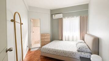 Una camera da letto con un letto, un comodino e una porta con porta asciugamani.