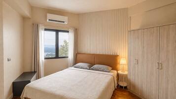Una camera da letto con un letto, un comodino, una lampada, un armadio e una finestra con tende.