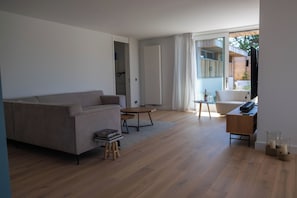 Uma sala de estar moderna com um sofá, uma mesa de centro e um rack para TV.