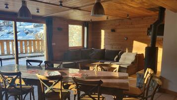 Ein gemütliches Holzinterieur mit Essbereich, Sofas und Kamin.