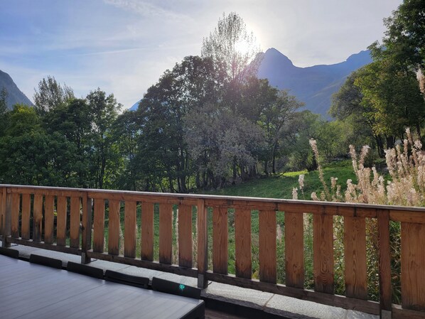 A wooden deck with a view of a mountainous landscape.