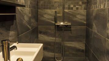Ein modernes Badezimmer mit Dusche, Waschbecken und Toilette.