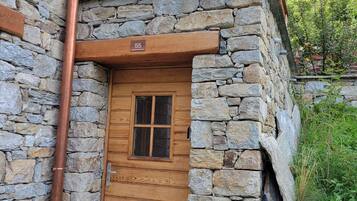 Ein Steinhaus mit einer Holztür und einem Balkon.