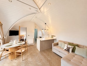 Un espacio habitable moderno estilo loft con comedor, kitchenette y una zona de estar acogedora.