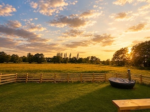 A grassy field with a wooden fence and a picnic table. - Leisure Lodges  (Street)