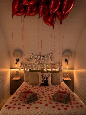 Un dormitorio con cama, almohadas y un cartel que dice 'recién casados'.