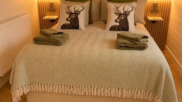 Un dormitorio con una cama grande, dos mesitas de noche y una alfombra de piel en el suelo.