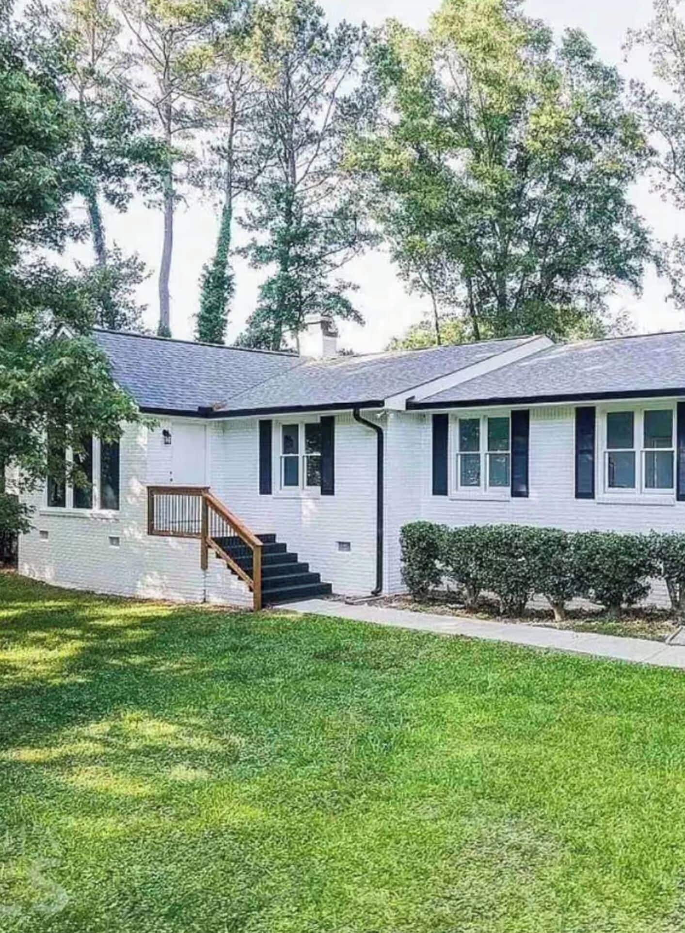 A single-story house with a front porch, a staircase leading to the entrance, and a well-maintained lawn.