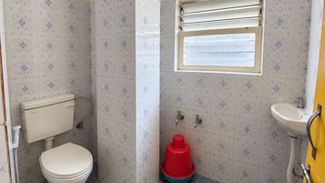 Un baño pequeño con inodoro, lavamanos y ventana.